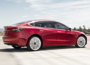 2019 Tesla Model 3: red rear quarter, driving